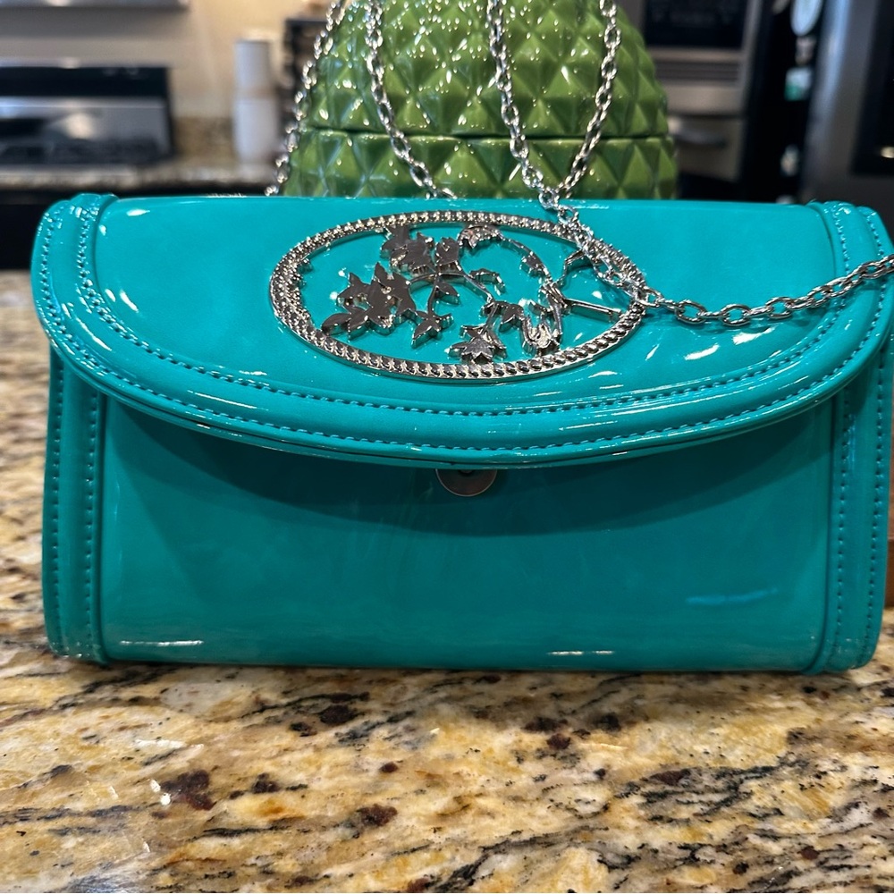 Melie Bianco Blue Vernis Leather and Silver Clutch with Elegant Oval Shape
